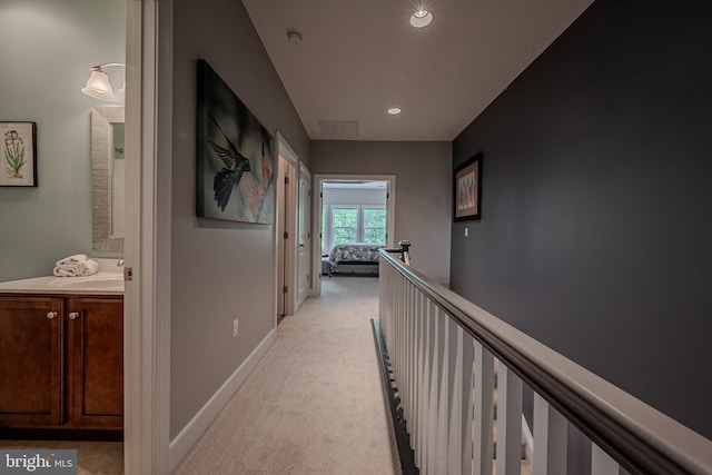 hall featuring light colored carpet