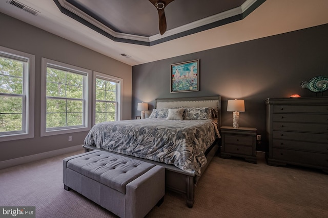 carpeted bedroom featuring a tray ceiling, ceiling fan, and crown molding