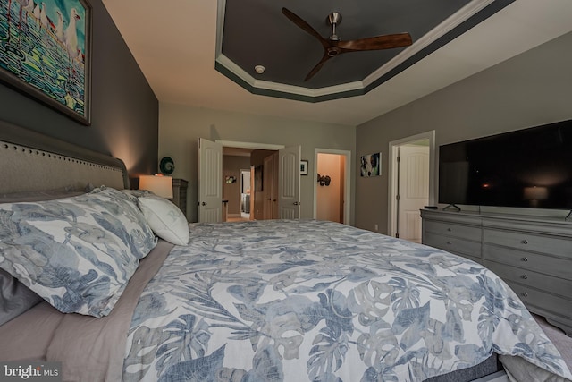 bedroom featuring a raised ceiling and ceiling fan