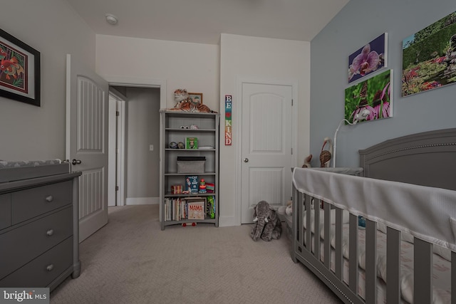 bedroom with a crib and light carpet