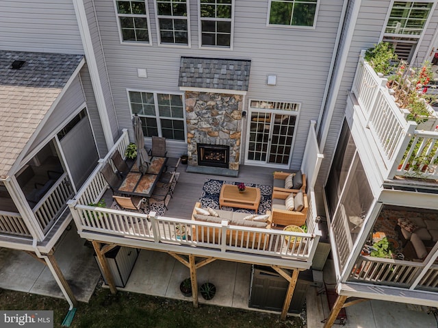 deck with an outdoor living space with a fireplace