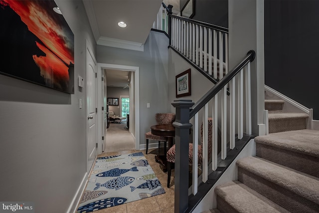 stairs featuring tile patterned flooring, ceiling fan, and crown molding