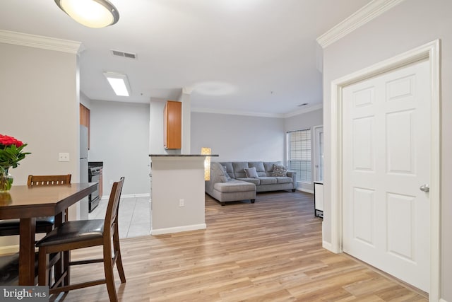 dining room featuring light hardwood / wood-style floors and crown molding