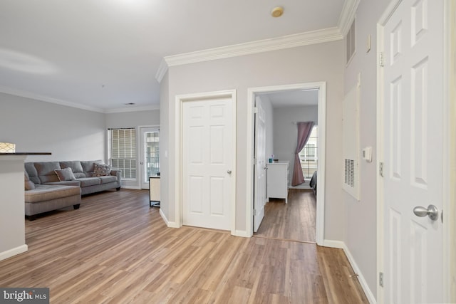 hall with light hardwood / wood-style floors and ornamental molding