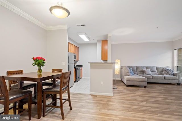 dining space featuring light hardwood / wood-style floors and ornamental molding