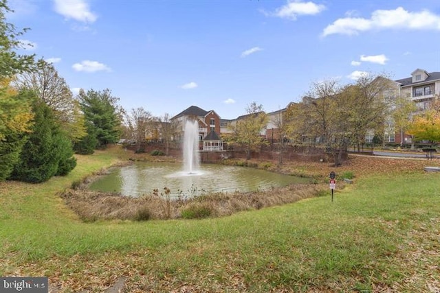 view of community with a yard and a water view