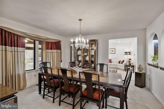 dining room with light carpet and an inviting chandelier