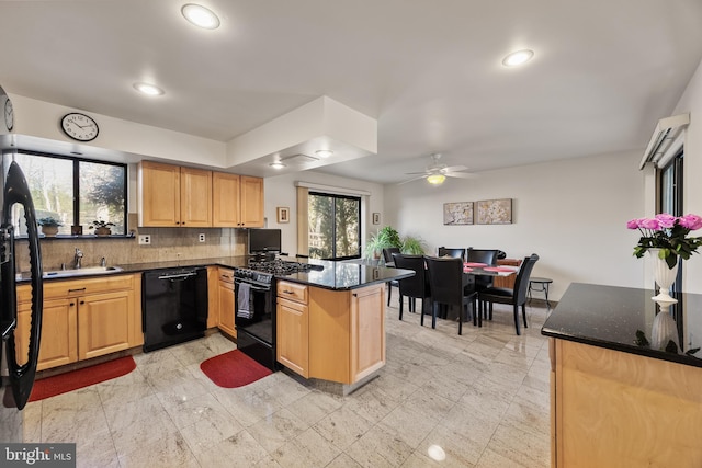 kitchen featuring kitchen peninsula, backsplash, ceiling fan, sink, and black appliances