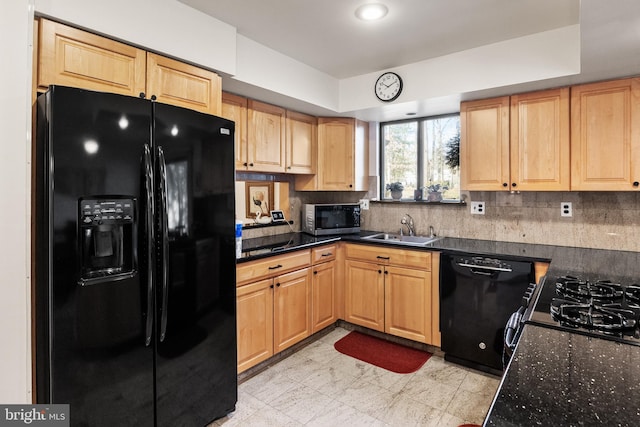 kitchen featuring black appliances, backsplash, dark stone countertops, and sink