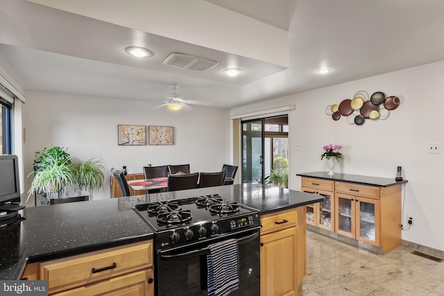 kitchen featuring black gas range, ceiling fan, and light brown cabinetry