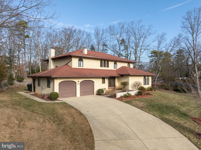 mediterranean / spanish-style house featuring a garage and a front lawn