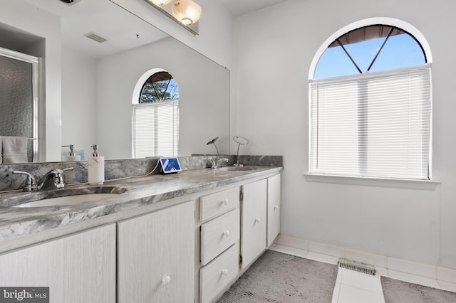 bathroom featuring tile patterned floors, vanity, and a shower with shower door