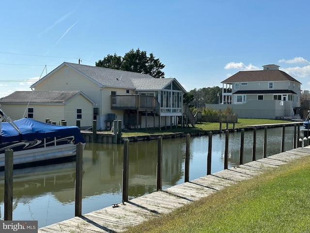 view of dock with a yard and a water view