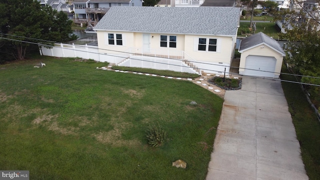 view of front of home with a garage, an outbuilding, and a front yard