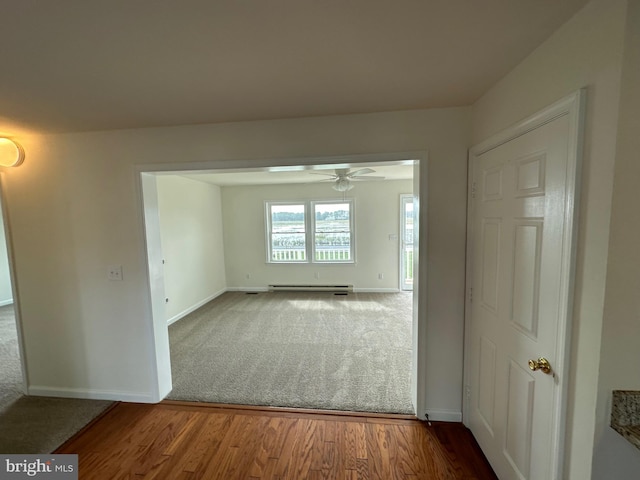 spare room with hardwood / wood-style flooring, baseboard heating, and ceiling fan