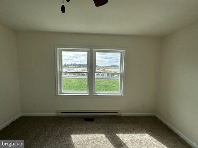 empty room featuring carpet, ceiling fan, a water view, and a baseboard heating unit