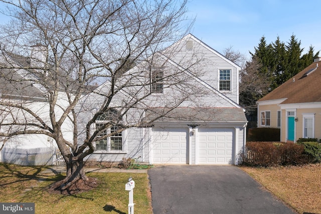 traditional-style home featuring an attached garage and driveway