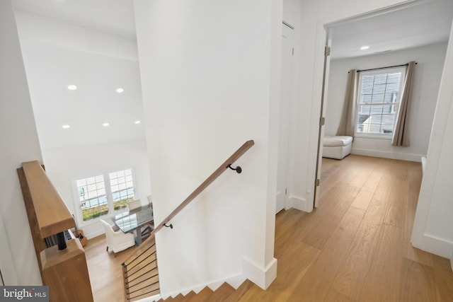 staircase with baseboards, plenty of natural light, and wood finished floors