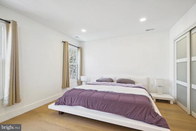 bedroom with recessed lighting, light wood-type flooring, baseboards, and visible vents