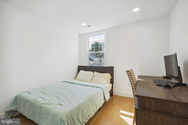 bedroom with recessed lighting, visible vents, baseboards, and wood finished floors