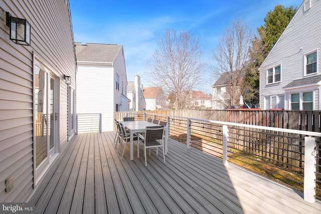 wooden deck featuring outdoor dining space and a residential view