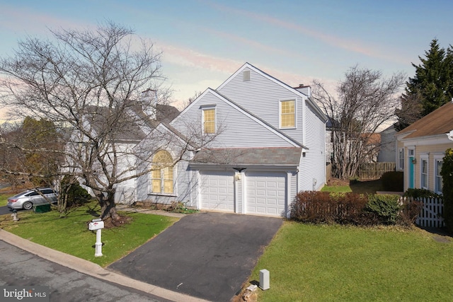 traditional home with a front lawn, aphalt driveway, fence, an attached garage, and a chimney