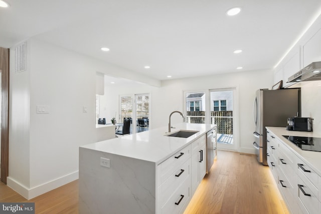 kitchen with a center island with sink, recessed lighting, appliances with stainless steel finishes, light wood-style floors, and a sink