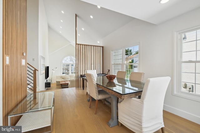 dining space featuring light wood finished floors, plenty of natural light, recessed lighting, and high vaulted ceiling