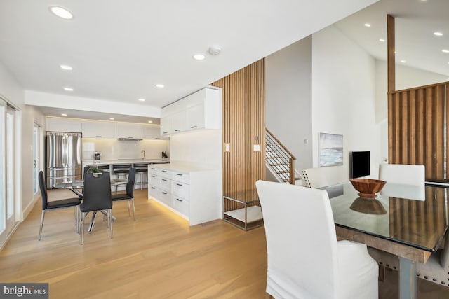 dining room with lofted ceiling, light wood-style flooring, and recessed lighting