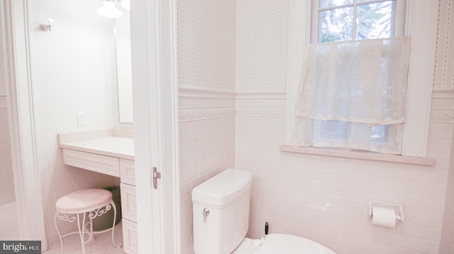 bathroom with tile walls and toilet