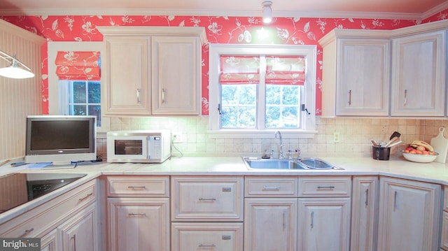 kitchen featuring backsplash, decorative light fixtures, crown molding, and sink