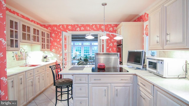 kitchen featuring crown molding, sink, hanging light fixtures, a breakfast bar area, and light tile patterned flooring