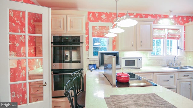 kitchen featuring decorative backsplash, double oven, crown molding, sink, and pendant lighting