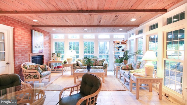 sunroom with beamed ceiling, a brick fireplace, and wood ceiling