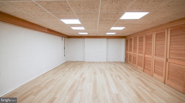 unfurnished room featuring light hardwood / wood-style floors and a drop ceiling