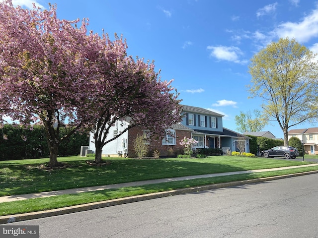 view of front facade featuring brick siding and a front yard