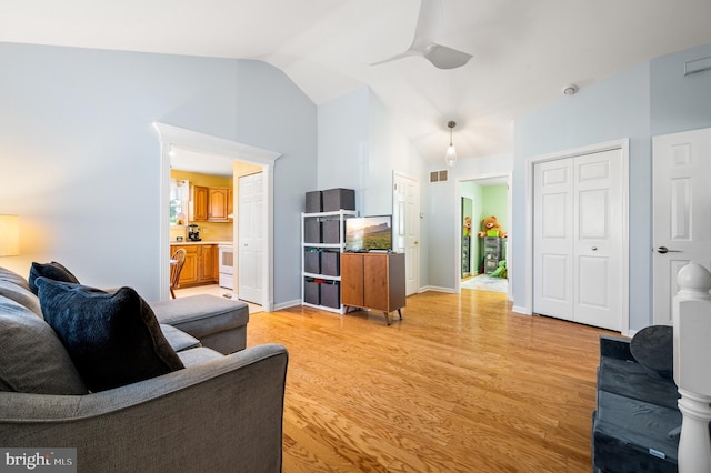 living room with visible vents, ceiling fan, baseboards, lofted ceiling, and light wood-style floors