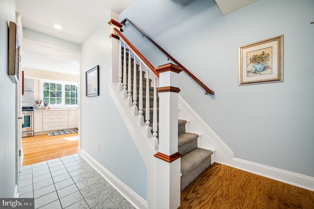 staircase with recessed lighting, baseboards, and wood finished floors