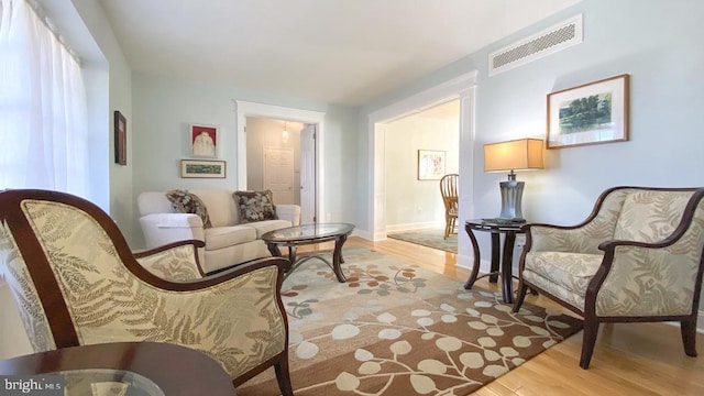 sitting room with visible vents, baseboards, and light wood-style floors