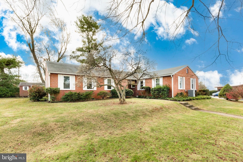 single story home with central air condition unit and a front lawn