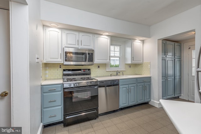 kitchen with white cabinets, sink, stainless steel appliances, and tasteful backsplash