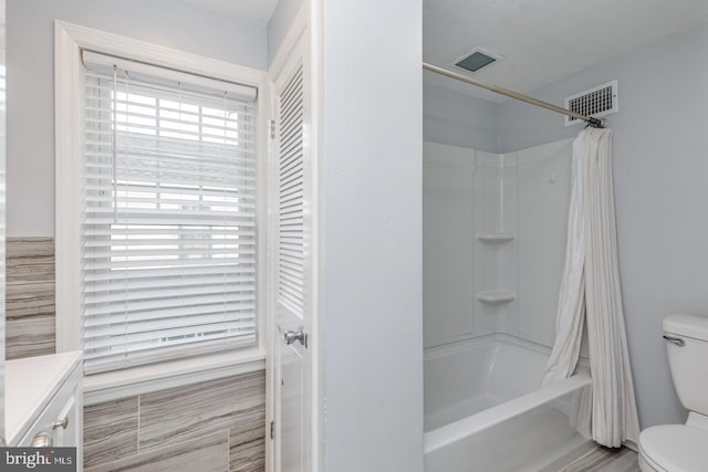 full bathroom with vanity, shower / bath combo, and toilet