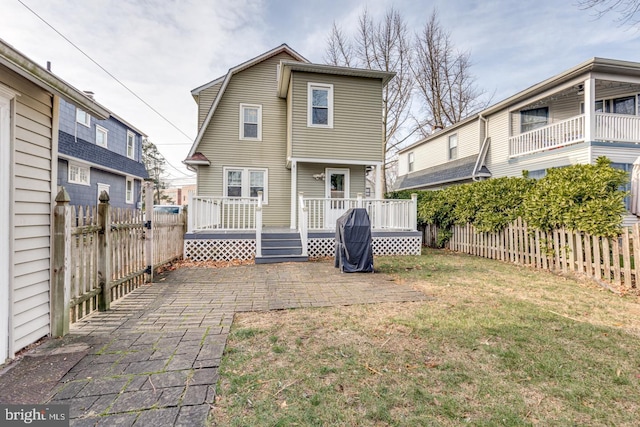 rear view of house with a lawn and a deck