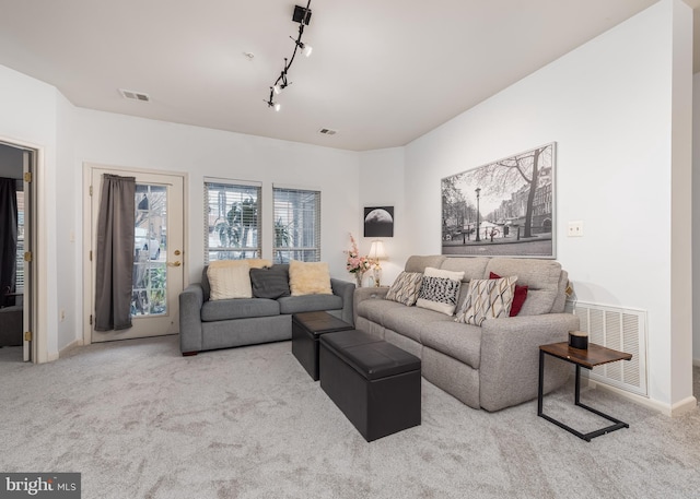 carpeted living room featuring rail lighting