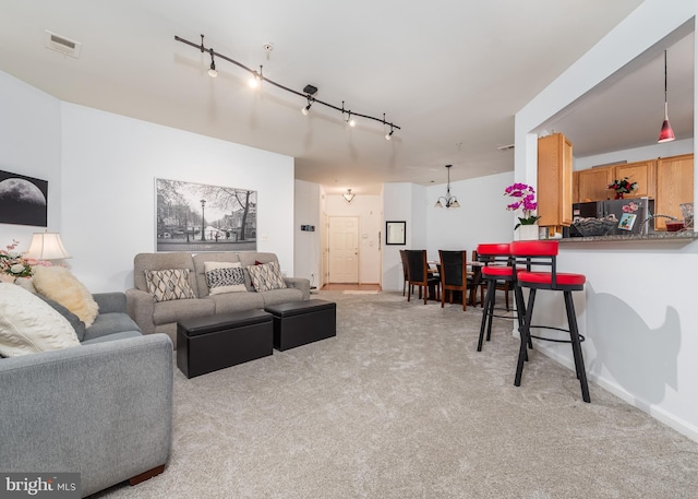 living room featuring light colored carpet and track lighting