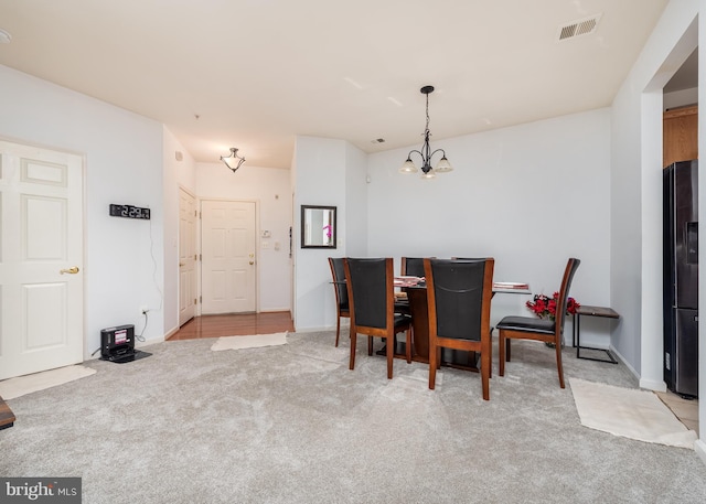 carpeted dining area with a notable chandelier