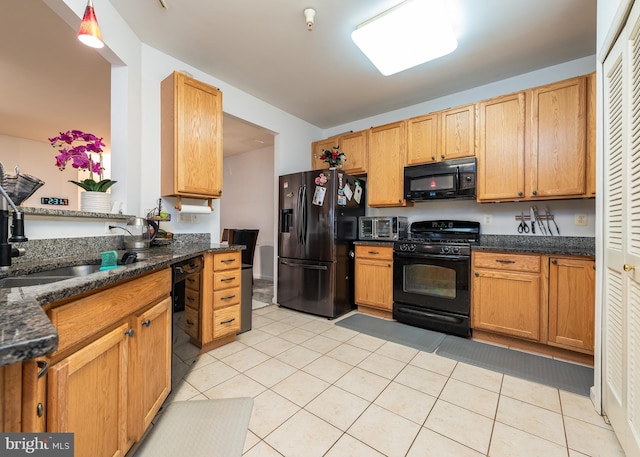 kitchen with black appliances, light tile patterned floors, sink, and dark stone counters