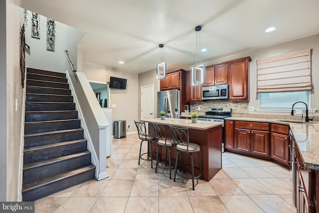 kitchen with pendant lighting, a center island, sink, and appliances with stainless steel finishes