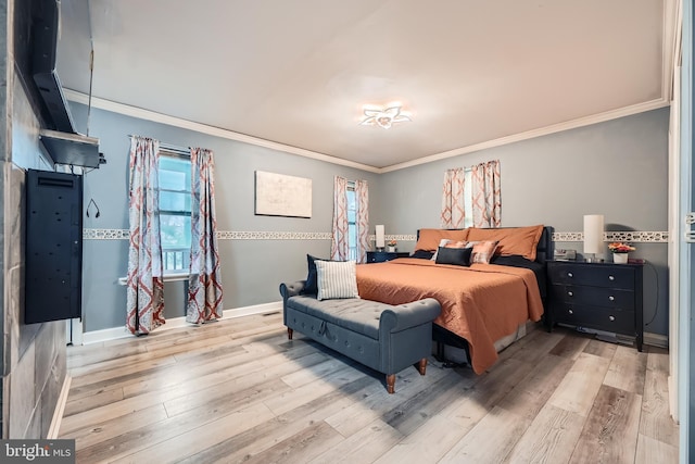 bedroom featuring crown molding and light hardwood / wood-style flooring