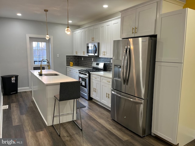 kitchen featuring stainless steel appliances, white cabinetry, a kitchen island with sink, and sink